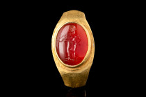 ROMAN GOLD RING WITH CARNELIAN INTAGLIO WITH GOD APOLLO

 Ca. AD 1-200
 A gold finger ring formed of a flat-section hoop, widened shoulders with de...