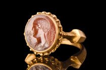 ROMAN MERCURY STONE INTAGLIO IN GOLD RING

 Ca. AD 100-300
 A red stone intaglio engraved with a left-facing portrait of Mercury (Greek Hermes), th...