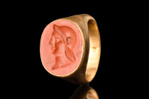 ROMAN GOLD RING WITH A HEAD OF A SOLDIER INTAGLIO

 Ca. AD 100-300
 A gold finger ring of Hening type I, composed of a slender round hoop with a ta...