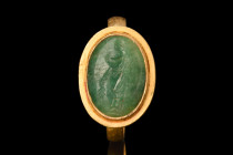 ROMAN GOLD RING WITH EMERALD INTAGLIO OF VICTORY

 Ca. AD 100-200
 A gold finger ring with a slender flat-section band and a sizable bezel set with...