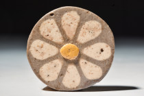 EGYPTIAN FAIENCE ROSETTE INLAY

 New Kingdom, 20th Dynasty, Ca. 1186 - 1069 BC
 A fine faience tile of a discoid form, decorated with a delicate ro...