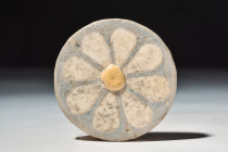 EGYPTIAN FAIENCE ROSETTE INLAY

New Kingdom, 20th Dynasty, Ca. 1186 - 1069 BC
A glazed faience inlay in the form of a rosette, set with an eight-pe...