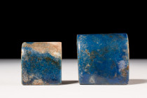 TWO EGYPTIAN LAPIS LAZULI HALF CYLINDER INLAYS 

 New Kingdom, Ca. 1550 - 1070 BC 
 A set of two inlays displaying a vibrant cobalt blue glaze. The...