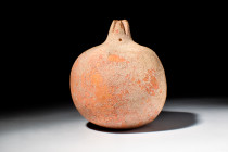 GREEK TERRACOTTA VOTIVE POMEGRANATE 

 Eastern Greek, Ca. 400 BC
 A naturalistic sculptural rendering of a pomegranate with a characteristically gl...