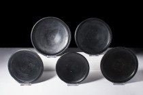 GROUP OF FIVE ATTIC BLACK-GLAZED FOOTED DISHES

 Ca. 400-350 BC
 A group of five black-glazed pottery dishes, each with a broad and shallow body th...