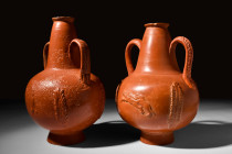 PAIR OF ROMAN RED-WARE NORTH AFRICAN AMPHORISKOI

 Ca. 3rd century AD
 A pair of redware amphoriskoi, crafted through a wheel-throwing technique. E...