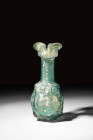 ROMAN GLASS OINOCHOE WITH TREFOIL SPOUT

 Ca. 3rd - 4th century AD
 A glass oinochoe featuring a rounded lower body with moulded decoration, tubula...