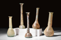 COLLECTION OF FIVE LARGE ROMAN GLASS BOTTLES

 Ca. AD 100-300 
 A group of five glass bottles. The shapes in this lot include globular, domed and p...