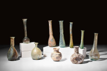 COLLECTION OF 10 ROMAN GLASS BOTTLES

 Ca. AD 100-300 
 A group of 10 glass bottles. This assortment includes three small flasks with rounded bodie...