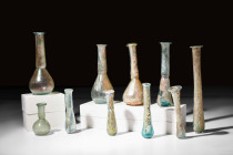 COLLECTION OF 10 ROMAN GLASS BOTTLES

 Ca. AD 100-300 
 A group of 10 assorted glass bottles, incorporating both piriform and cylindrical unguentar...