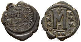 JUSTINIAN I.(527-565).Constantinople.Follis.

Obv : D N IVSTINIANVS P P AVC.
Helmeted, cuirassed bust facing, holding cross on globe and shield wit...