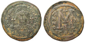 Justinian I, 527-565. Follis (bronze, 22.82 g, 40 mm), Constantinople. Helmeted, draped, and cuirassed bust facing, holding globus cruciger and shield...