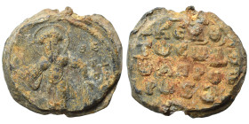 Byzantine seal (lead, 19.44 g, 24 mm). Nimbate saint standing, facing. Rev. Legend in four lines. Fine.