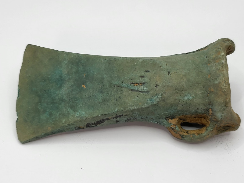 Bronze Age Socketed Axe
A cast bronze axe head. The head is socketed, with an o...
