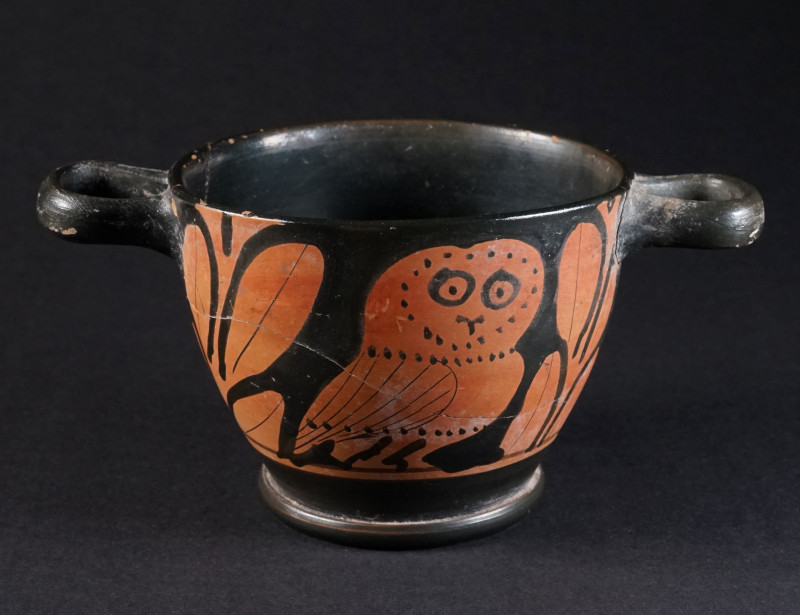 A GREEK RED-FIGURED OWL SKYHOS Apulia, circa 4th century BC. Two handled black g...