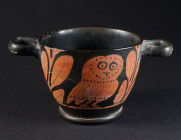 A GREEK RED-FIGURED OWL SKYHOS Apulia, circa 4th century BC. Two handled black glazed pottery drinking vessel decorated on both sides with a facing ow...