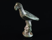 A ROMAN BRONZE FIGURE OF AN EAGLE Circa 2nd-3rd century AD. The bird stands lofty on a round profiled base. The body is all over decorated with a mixt...