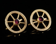 A PAIR OF ROMAN GOLD EARRINGS WITH GARNETS Circa 1st-2nd century AD. An extremely fine pair of Roman wheel-shaped gold earrings formed from beaded gol...