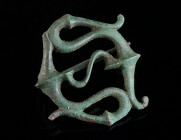 A ROMAN BRONZE OPENWORK TRUMPET BROOCH Circa 2nd-3rd century AD. Fine plate brooch with a complex Celtic trumpet-style design featuring an S-shaped or...