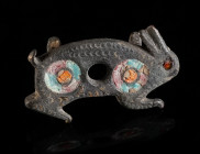 A ROMAN BRONZE BELT FITTING IN THE FORM OF A HARE Circa 2nd century AD. The body of the hare is decorated with enamel and a punched design. On the rev...