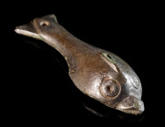 A ROMAN BRONZE APPLIQUE IN THE FORM OF A DOLPHIN Circa 2nd-3rd century AD. Worked in relief, the eyes indicated with circled dots, at the tail a rivet...