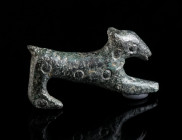 A GREEK/ROMAN BRONZE FIGURINE OF A DOG Circa 4th century BC - 3rd century AD. Figurine of a stretching dog, the body decorated with punched ring motif...
