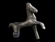 A ROMAN BRONZE FIGURE OF A HORSE Circa 2nd-3rd century AD. Figure of a striding horse with the right foreleg raised; legs partly broken. L 45 mm, H 43...
