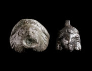 TWO APPLIQUES IN THE SHAPE OF THEATRICAL MASKS Circa 2nd-3rd century AD. The larger piece with a square stud on the reverse, the small mask with an ad...