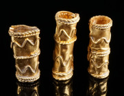 THREE MATCHING CYLINDRICAL GOLD BEADS Circa 3rd-4th century AD. Spacer beads made of gold sheet metal, decorated with undulating and twisted gold wire...