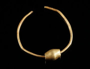 A PREHISTORIC GOLD BEAD ON A HOOP Circa 2nd-1st millennium BC. Biconical bead on an open hoop made of gold wire. L 8 mm (bead), Diameter 29 mm (hoop);...