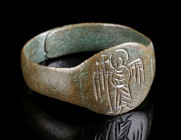 A BYZANTINE BRONZE RING WITH AN ANGEL Circa 6th-9th century AD. Ring with roundish bezel depicting an angel with halo and cross staff standing facing....