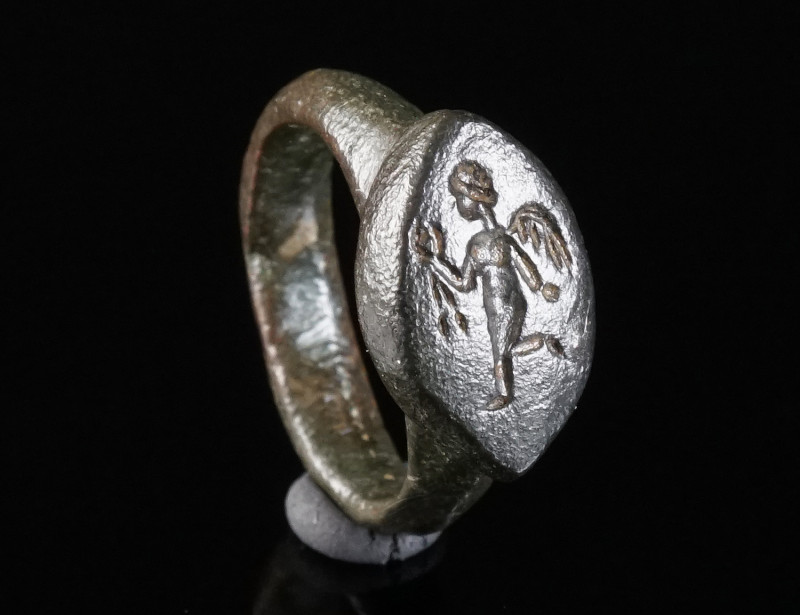 A SMALL ROMAN BRONZE RING WITH EROS Circa 3rd century AD. Small ring with a nave...