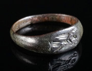 A ROMAN BRONZE RING WITH VICTORY Circa 2nd-3rd century AD. Bronze ring with oval bezel depicting Victory advancing right, holding wreath and palm fron...