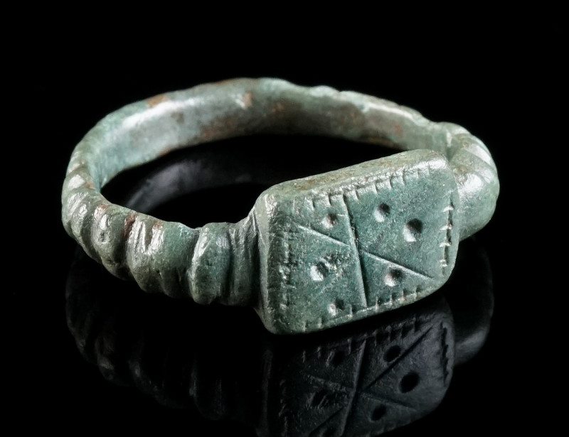A LATE ROMAN BRONZE RING WITH A STAR DESIGN Circa 4th century AD. Ring with rect...