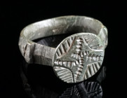 A MEDIEVAL BRONZE RING WITH AN ORNAMENTAL DESIGN Circa 13th-15th century AD. With decorated circular bezel and offset shoulders. Ring size 60 (EU)

Ex...