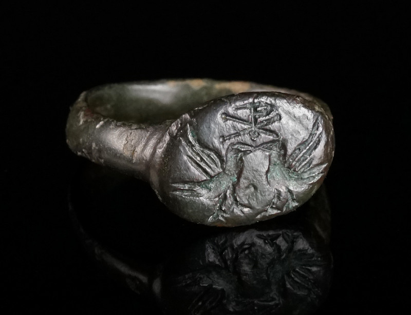 A BYZANTINE BRONZE RING WITH TWO DOVES AND A CHRISTOGRAM Early Byzantine, circa ...