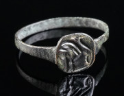 AN EARLY BYZANTINE BRONZE RING WITH A LION Circa 6th-7th century AD. With a circular bezel engraved with a lion facing to the left. Ring size 63 (EU)
...