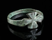 AN EARLY BYZANTINE BRONZE RING WITH A CROSS Circa 6th-7th century AD. Small bronze ring with a bezel in the shape of a cross (pattée). Ring size 44 (E...