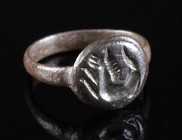 A LATE ROMAN BRONZE RING WITH A HORSE OR HIPPOCAMPUS Circa 4th century AD. The circular bezel engraved with a prancing horse or a hippocampus (?). Rin...