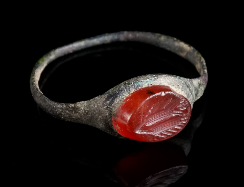 A DELICATE ROMAN BRONZE RING WITH A CARNELIAN INTAGLIO Circa 2nd-3rd century AD....