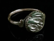 A LATE ROMAN BRONZE RING WITH STYLISED ANIMALS/CREATURES Circa 4th century AD. With offset round bezel depicting two stylised birds or some kind of cr...