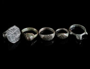 A GROUP OF FIVE SMALL MEDIEVAL/EARLY MODERN BRONZE RINGS Circa 14th-16th century AD. All with decorated bezel; one probably a ring-shaped seal (outer ...