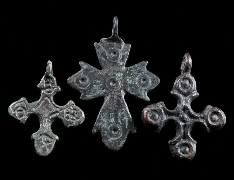 A GROUP OF THREE BYZANTINE BRONZE CROSS PENDANTS Circa 6th-12th century AD. Thre...