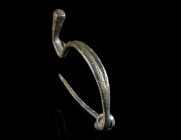 AN IRON AGE/EASTERN CELTIC BRONZE BOW BROOCH Circa 4th-3rd century BC. A decorated Thracian Type/La Tène Type brooch. Made of one piece with spring an...