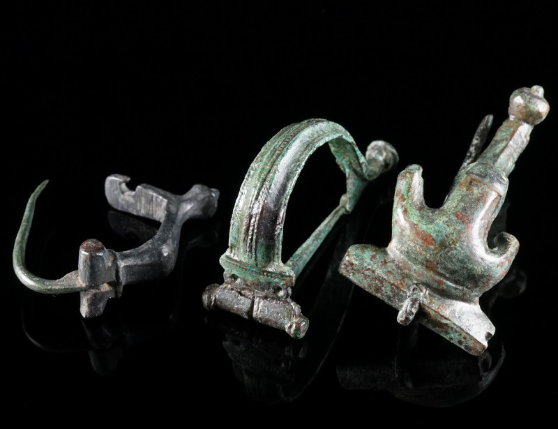 A GROUP OF THREE ROMAN BRONZE BROOCHES Circa 1st-3rd century AD. A knee brooch, ...