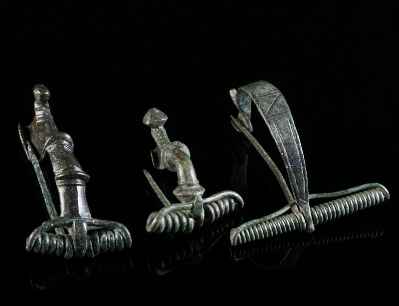 A GROUP OF THREE ROMAN BRONZE BROOCHES Circa 1st-3rd century AD. Two strongly pr...
