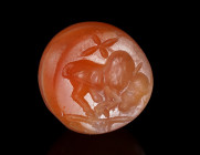 A SASANIAN CARNELIAN AGATE STAMP SEAL WITH A ZEBU Circa 3rd-7th century AD. Stamp seal with a zebu to right and a star above; the centre perforated wi...