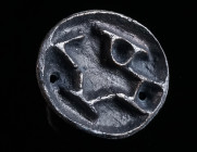 A BYZANTINE BRONZE BREAD STAMP Circa 5th-8th century AD. Oval in form, with an abbreviated Greek inscription and a small, pierced handle at the back. ...