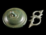 TWO ROMAN BRONZE APPLIQUES Circa 2nd-3rd century AD. An openwork belt fitting worked in Romano-Celtic 'Trumpet-style', and a shield-boss-shaped circul...