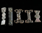 A GROUP OF FIVE ROMAN BRONZE BELT FITTINGS Circa 1st century AD, and 4th-5th century AD. An early Roman fitting with remains of tin plating, and four ...